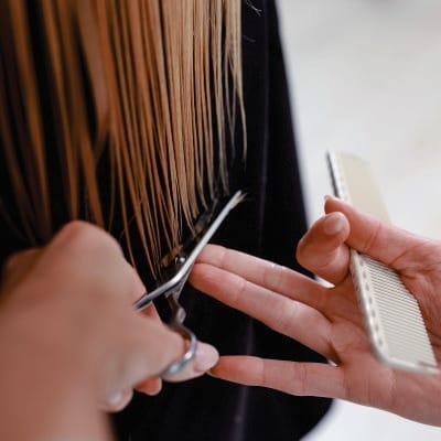 Peluquera cortando el cabello con tijeras y peine