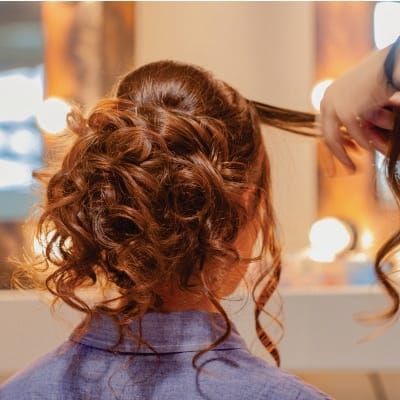 Peluquera realizando un recogido con rizos