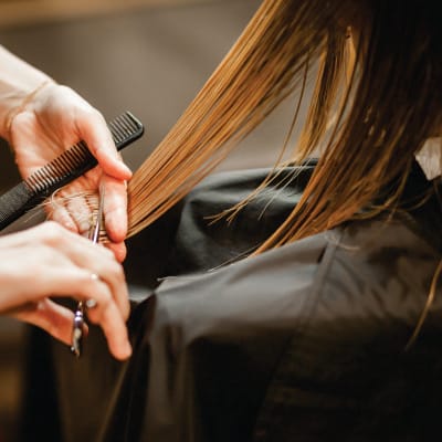 Estilista realizando un corte de cabello a domicilio